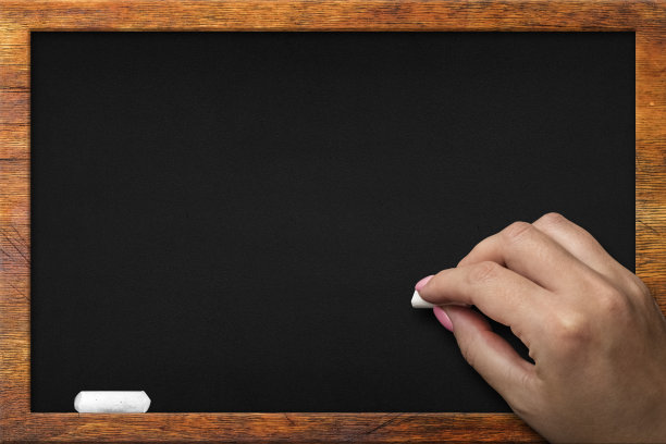 空黑板，木框黑色黑板。一个女人用白色的粉笔写字图片下载