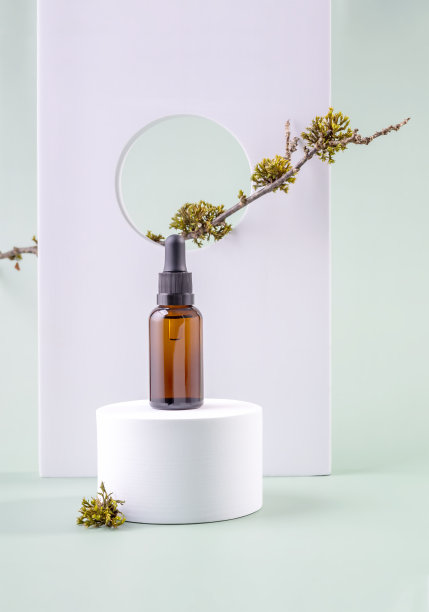 化妆用玻璃制成的瓶子，圆形的讲台上有一个滴管，树枝上有苔藓。天然化妆品模型概念图片下载