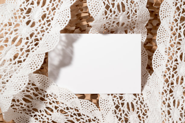 蕾丝背景上的空纸卡。婚礼请柬设计，新生宝宝贺词卡。白色花边的空白纸图片下载