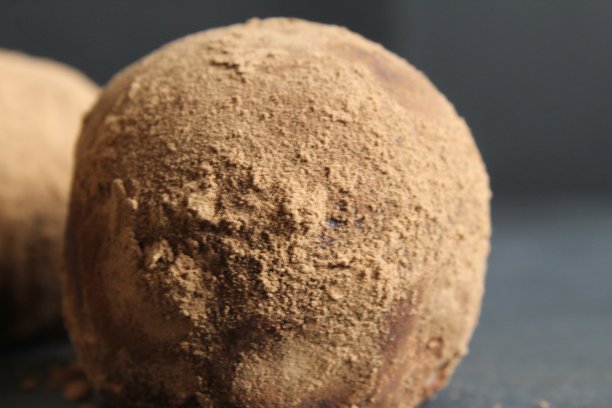 圆形巧克力蛋糕在可可特写在黑色石头的背景。食物自制的甜点图片下载