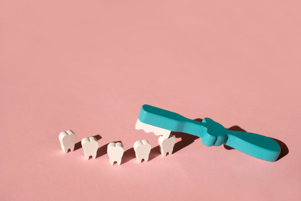 一个玩具牙刷在粉红色的背景上刷牙。图片下载