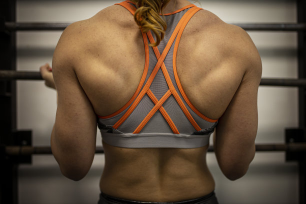 肌肉发达的女运动员在体育馆举起沉重的杠铃图片下载