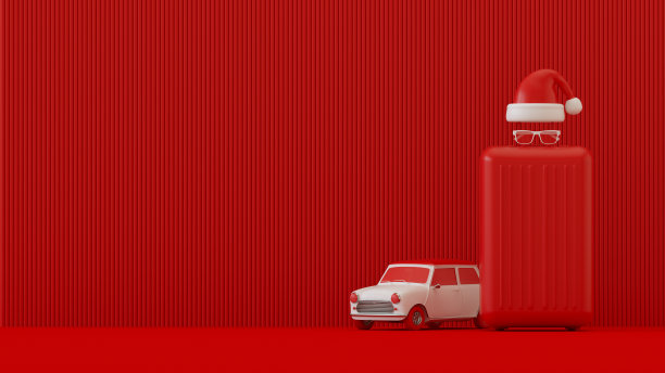 圣诞节旅行假日概念手提箱行李，汽车和圣诞老人帽子在红色背景图片下载
