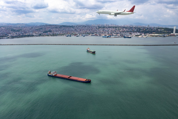 飞机在货船上方飞行。图片下载