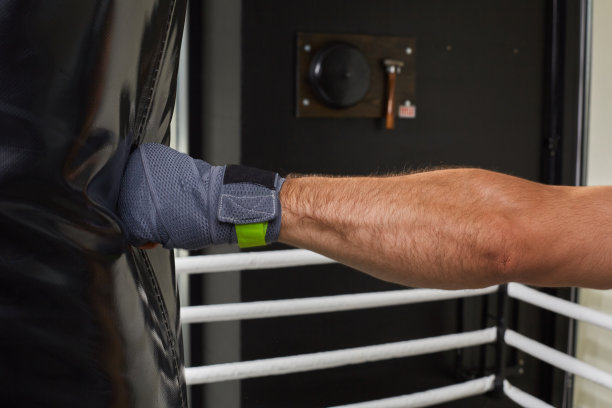 年轻的拳击手正在练习击打沙袋的技巧图片下载