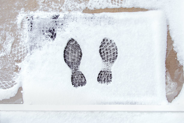 冬季被雪覆盖的户外地毯上的鞋印的高角度视角图片下载