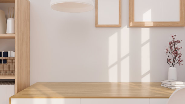 近距离舒适的斯堪的纳维亚木制办公桌和白色墙壁上的空白海报框架。图片下载
