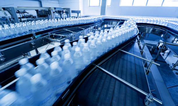 现代化饮料厂的传送带上的瓶装饮用水。图片下载