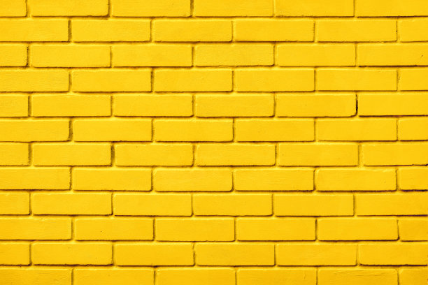 粉刷砖设计黄色墙体背景块。自然图案肌理背景黄砖墙色漆块图案。砌块纹理黄漆，墙砖底色暖图片下载