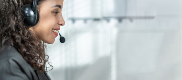 拉丁美洲美丽的商业妇女的肖像微笑工作在办公室。漂亮的职业女职员职员穿着正装坐在工作场所的桌子上，使用笔记本电脑支持客户。图片下载