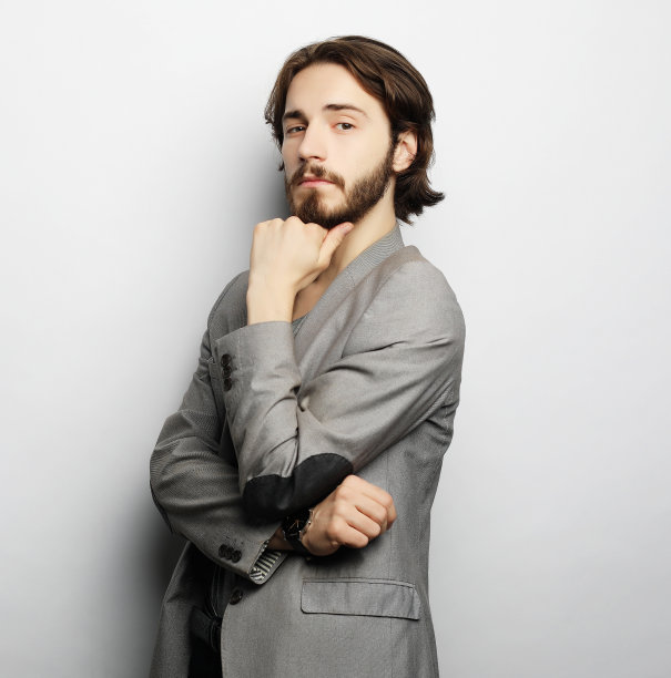 一名年轻男子的肖像在白色背景下摆姿势图片下载