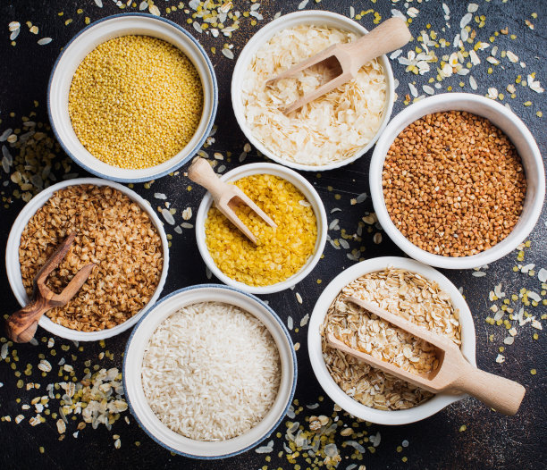 各种谷物片大米，小米，荞麦，燕麦片。白色陶瓷碗里的超级食物，深色的混凝土背景。前视图。图片下载