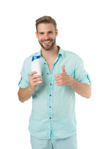 一名留着胡须的男子手持塑料瓶。帅哥注重外表，使用化妆品或卫生用品。男人展示他最喜欢的洗发水和护发素。香波极力推荐产品图片下载
