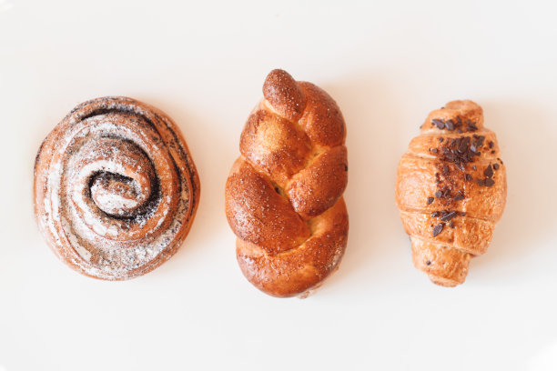 甜面包卷漩涡，牛角包和泡芙孤立在白色的背景图片下载