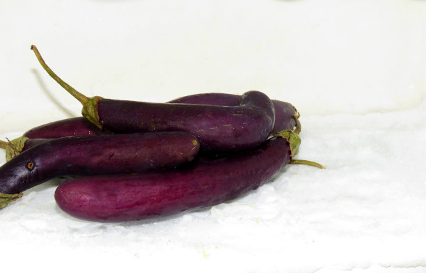 茄子在冰面上。保持蔬菜新鲜的理念，把茄子放在冰箱里的冰块上，使蔬菜长期保持新鲜。食品防腐剂的概念。图片下载