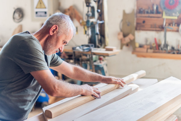 站在那里的老人正在用手臂打磨木头图片下载