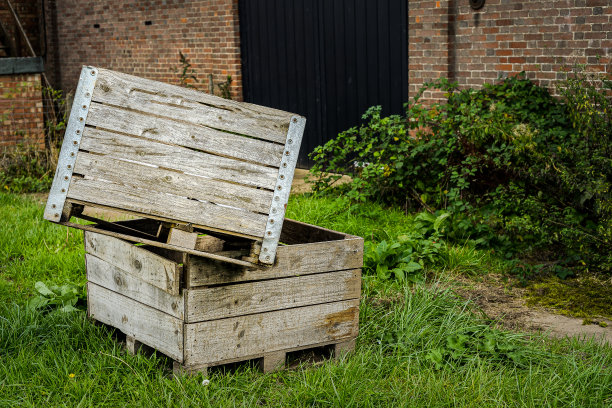 农场建筑外的草地上，一堆堆的木水果箱图片下载