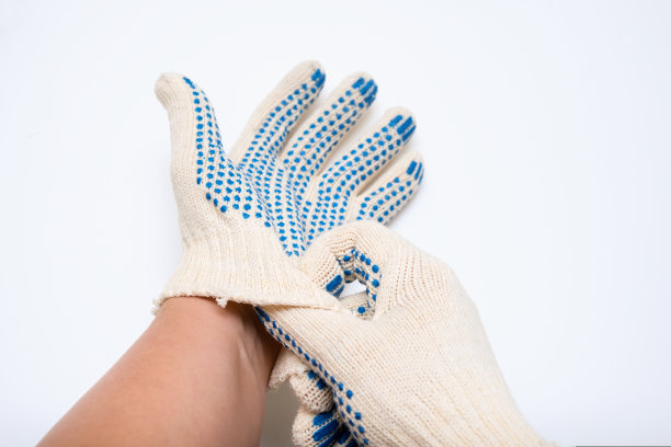 工人、建筑工人在白色背景下戴着施工编织的斑点防护手套图片下载