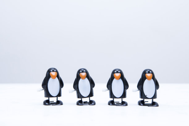 四卷企鹅玩具在一排上面的复制空间图片下载