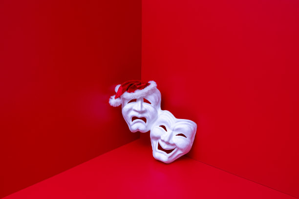 闪亮的圣诞老人帽子上的白色剧院面具在红房间的角落图片下载