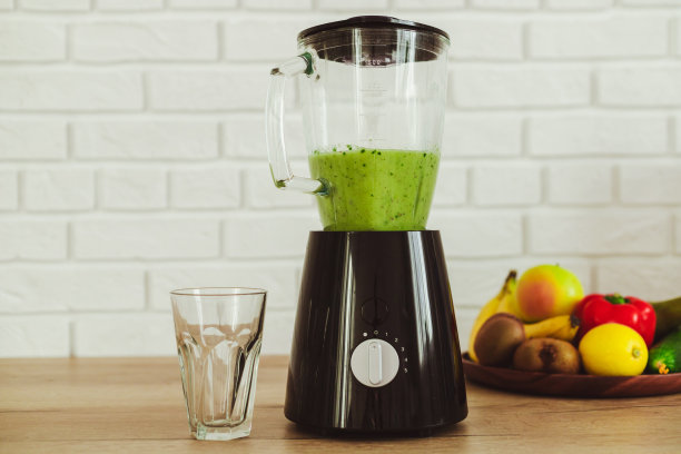 厨房里的固定搅拌机里有健康的绿色冰沙和配料图片下载