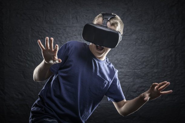 男孩使用虚拟现实耳机反应和跳跃的东西，他看到了可怕的图片下载