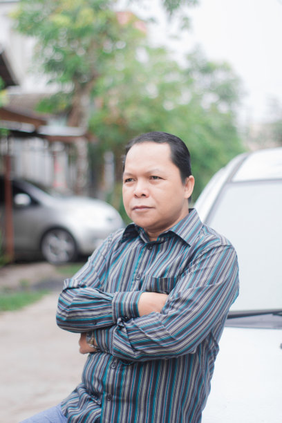 商人靠在一辆汽车旁图片下载