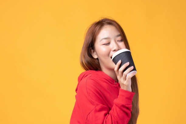 手拿外卖咖啡杯的年轻亚裔女子图片下载