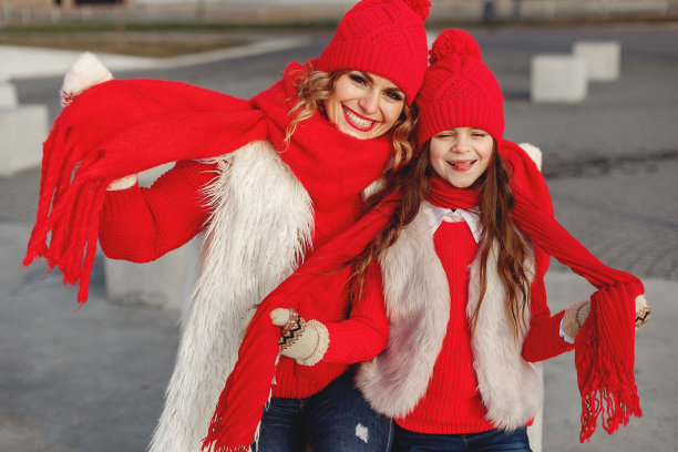 母亲和孩子戴着针织的冬季帽子在冬季公园玩耍图片下载