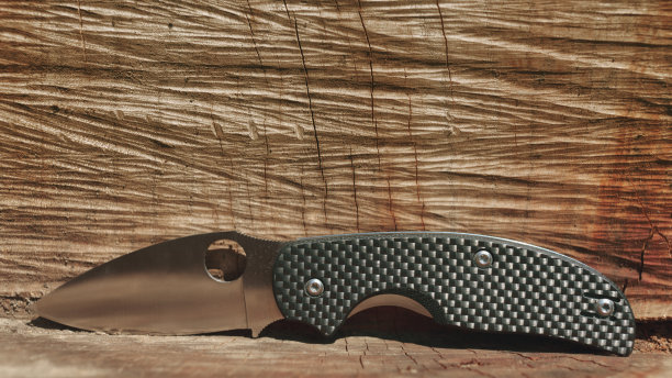 袖珍刀和棕色木质表面图片下载