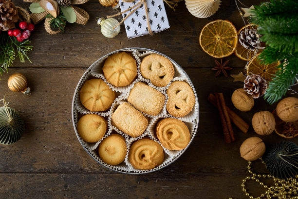 甜烤饼干在金属盒。黑色木制背景上的圣诞装饰图片下载