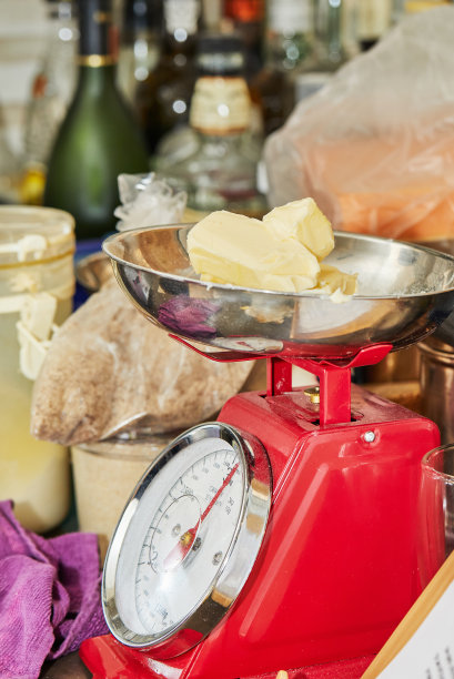 厨师在厨房用秤称量黄油，制作馅饼面团图片下载