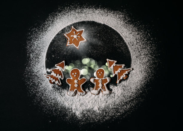 概念上的地球是由糖粉制成的。新年快乐，圣诞快乐概念形象。几个姜黄色的人走在圣诞树饼干森林与伯利恒之星在他们上方图片下载