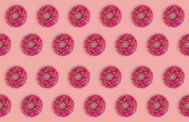 粉色背景下的草莓甜甜圈。甜味食物的无缝质感图片下载