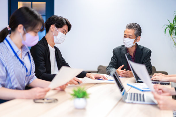 商务人士戴着面具开会图片下载