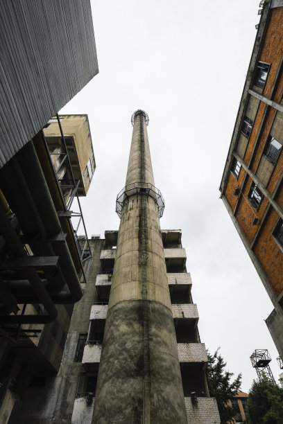 在阴天拍摄的成都，古老的红砖建筑和高大的工业烟囱图片下载