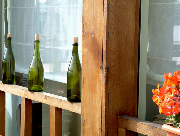 抽象背景与玻璃瓶。现代的室外室内餐厅。窗台上有橙色的天竺葵。图片下载