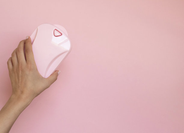 手握粉红色的手持地毯清扫粉红色的背景。复制文本空间。前视图。家里干净的概念图片下载