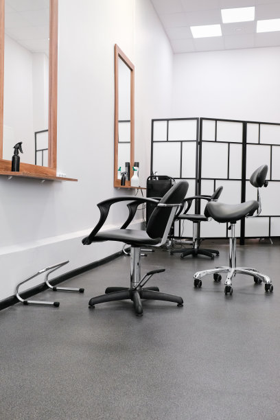 美发师，椅子和镜子准备好接待客人。沙龙内部有美容设备和家具。图片下载