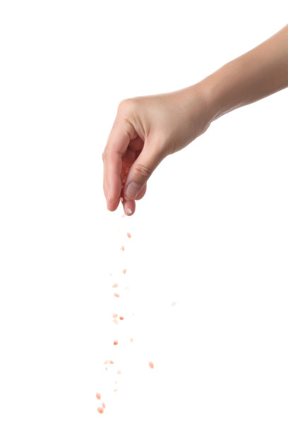 手撒粉红色的盐孤立的白色背景图片下载