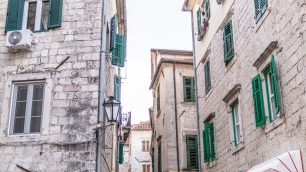 黑山，地道的老城科托尔的狭窄街道，有石墙的房子和带百叶窗的窗户。我们看到老房子和非常狭窄的库存照片图片下载