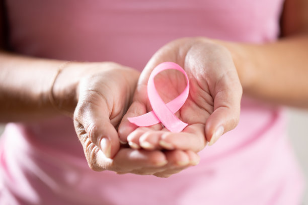 女性手拿粉红丝带，提高预防乳腺癌的意识。图片下载