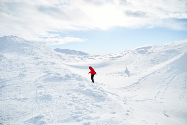 一名女登山运动员在覆盖着新雪的山上行走。喀尔巴阡山脉图片下载