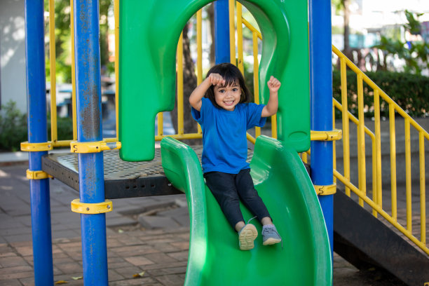 亚洲女孩在操场上玩耍，笑得开心图片下载