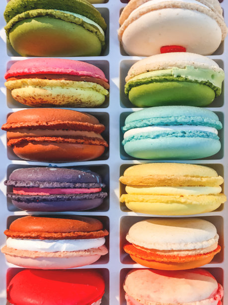 色彩鲜艳的杏仁饼。盒子里的美味糕点的特写照片。彩虹蛋糕和鲜奶油。图片下载