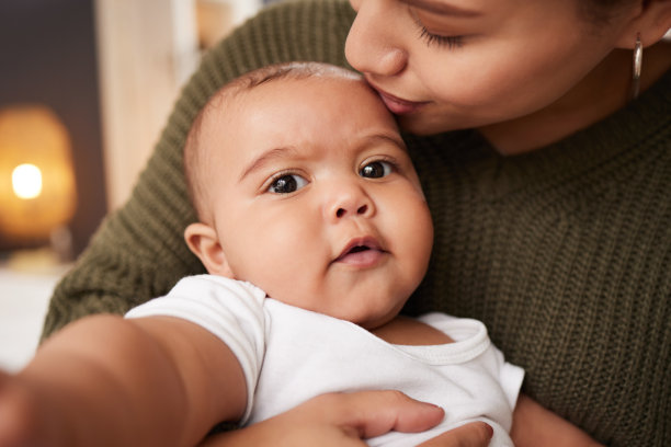 一名年轻妇女在家中抱着孩子图片下载