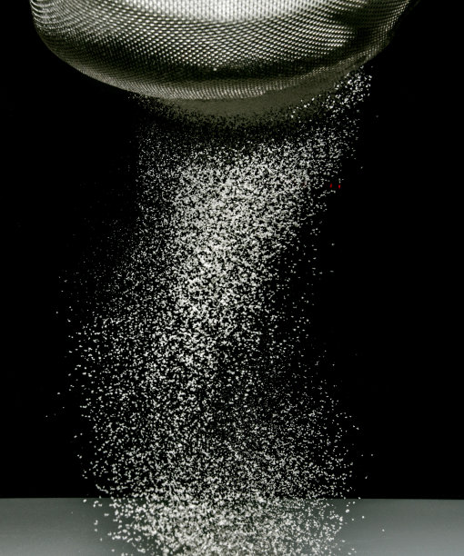 在黑色背景上筛面粉图片下载