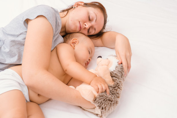 妈妈抱着刺猬玩具，和新生女儿一起睡觉图片下载