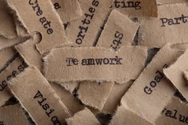 团队合作字在纸上合上，企业创意激励理念图片下载