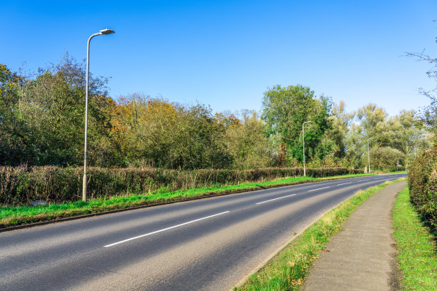 道路与汽车交通穿越美丽的乡村土地图片下载